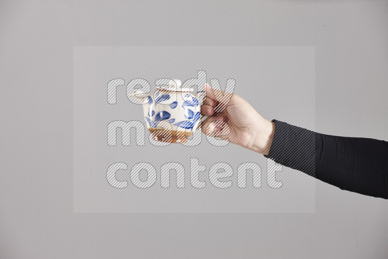 A woman in black abaya holding different pottery essentials in different positions