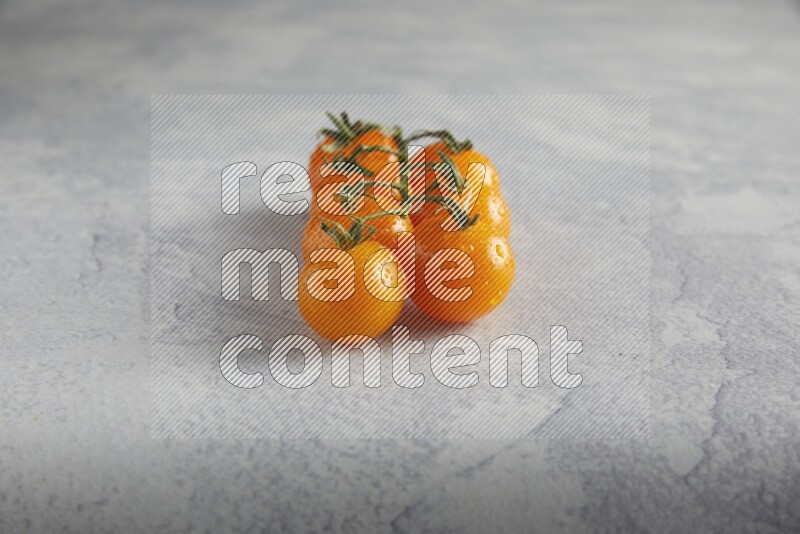 Orange cherry tomato vein on a light grey textured background 45 degree