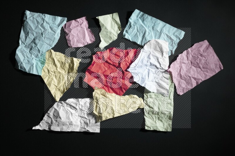 Crumpled multicolored paper on black background