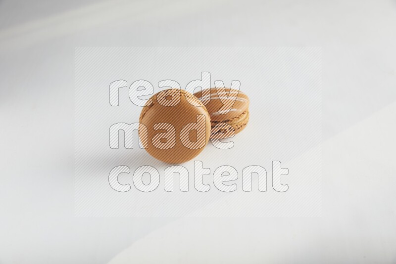 45º Shot of of two assorted Brown Irish Cream, and Brown Maple Taffy macarons  on white background