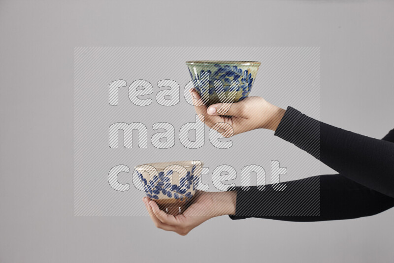 امرأة ترتدي عباءة سوداء تحمل أدوات فخارية مختلفة في أوضاع متعددة