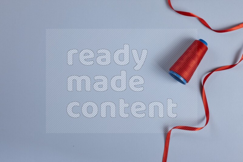 مجموعة من أدوات الخياطة والتفصيل حمراء اللون على خلفية زرقاء