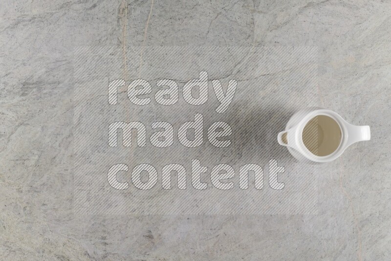 A ceramic milk jug on grey marble background