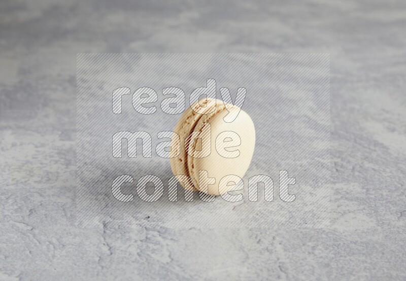 45º Shot of white marbleCaramel fleur de sel macaron on white  marble background