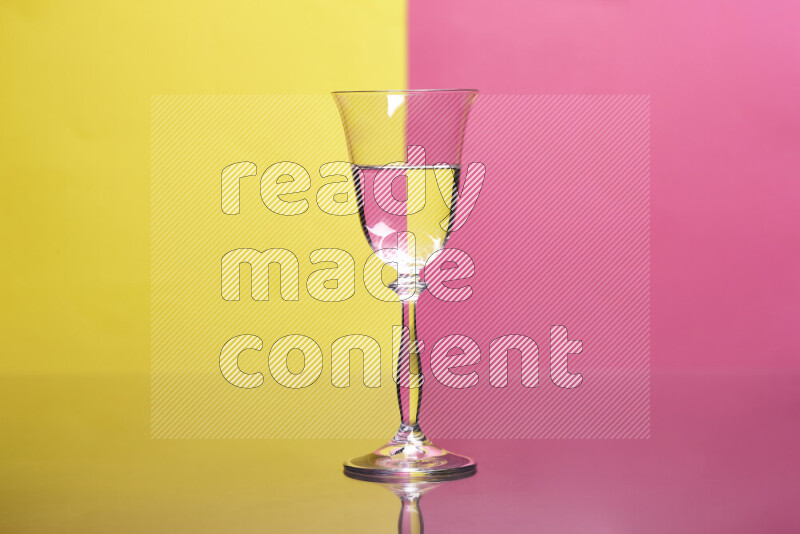 The image features a clear glassware filled with water, set against yellow and pink background