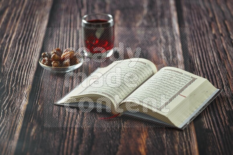 Quran with dates, prayer beads and different drinks all placed on wooden background