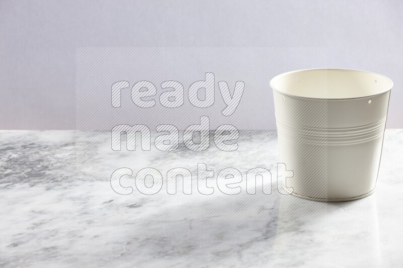 An empty white plant pot on grey marble background