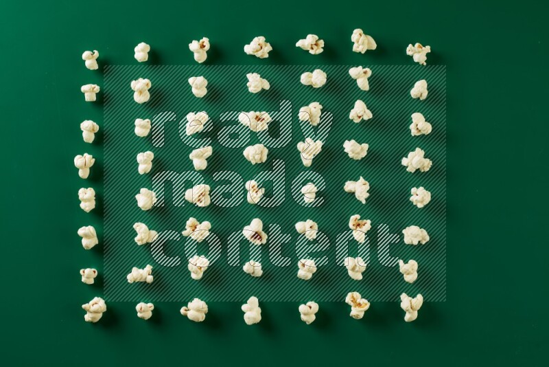 Popcorn flakes on a green background in a top view shot