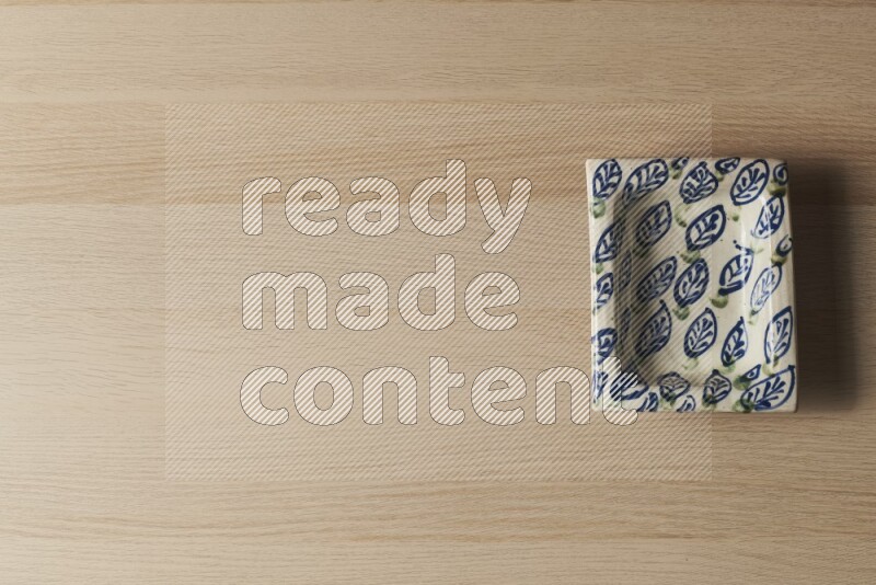 A decorative pottery plate on light wooden background