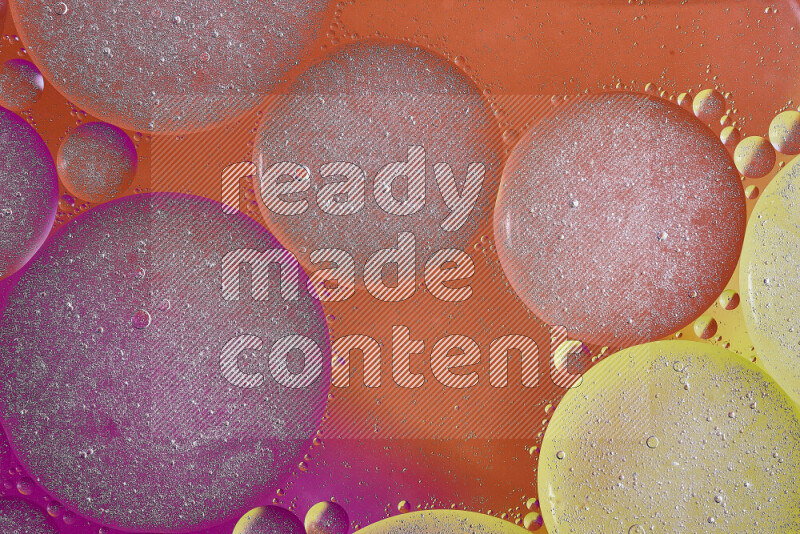 Close-ups of abstract oil bubbles on water surface in shades of yellow, orange and pink