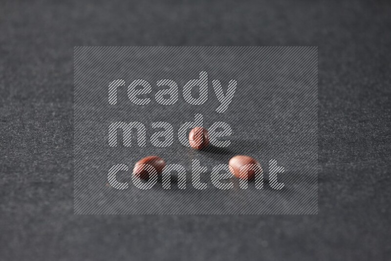 3 حبات من الفول السوداني علي خلفية سوداء