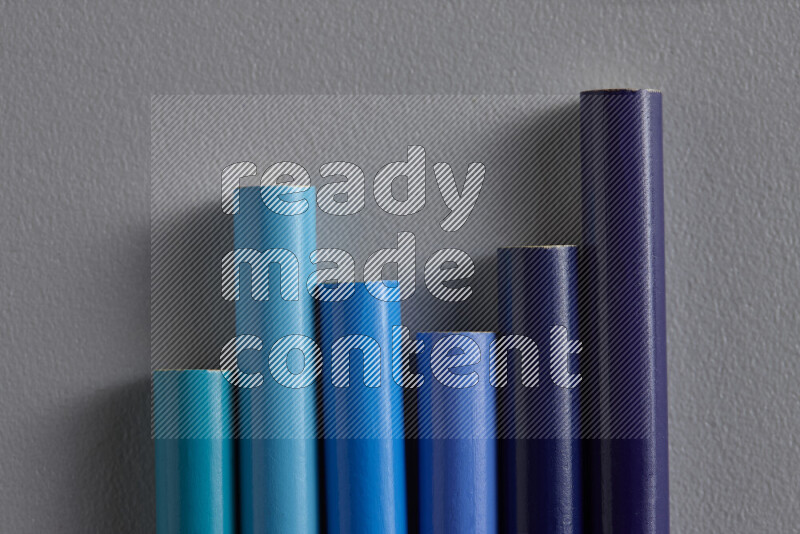 مجموعة من أقلام الرصاص الملونة مرتبة لتعرض تدرجا من الألوان الزرقاء علي خلفية رمادية