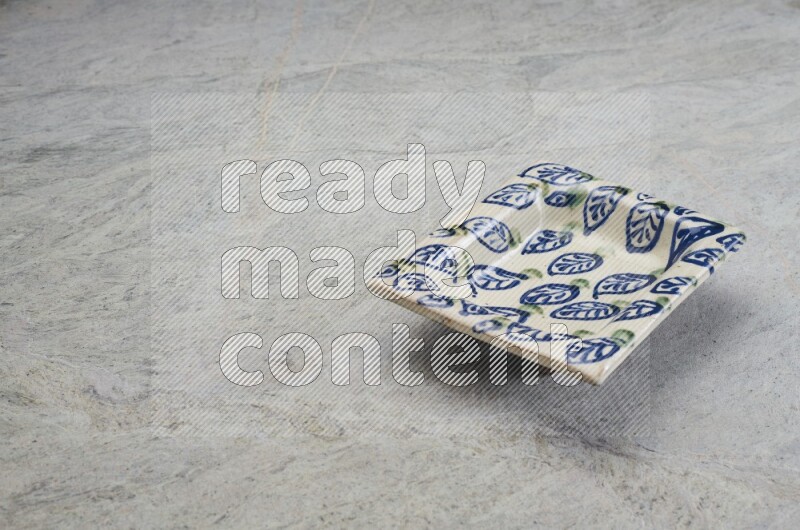 A decorative pottery plate on grey marble background