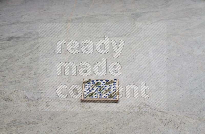 Top view shot of a pottery coaster\ tile on beige marble flooring