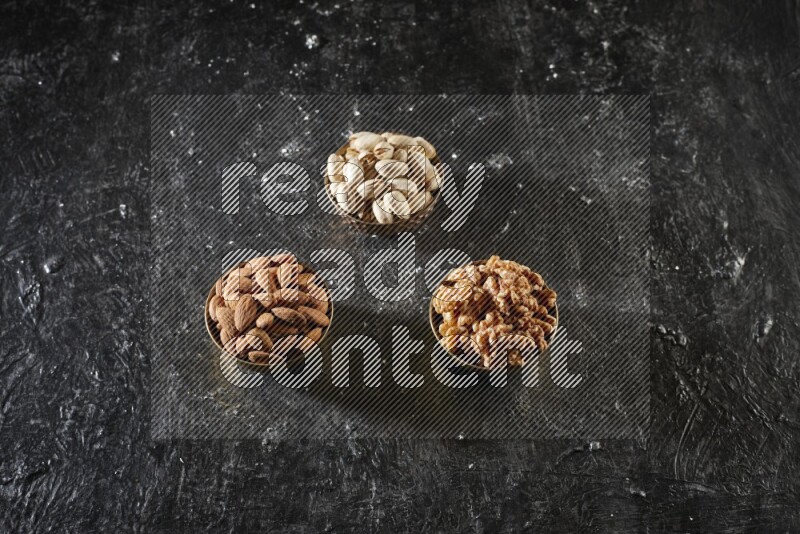 Nuts in a metal bowl in a dark setup