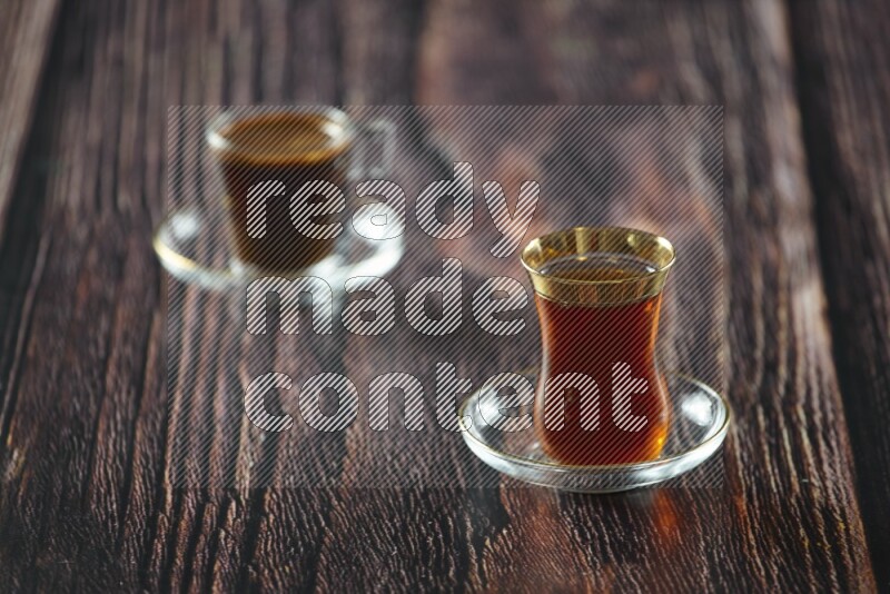 A tea glass cup with dates and coffee on wooden background