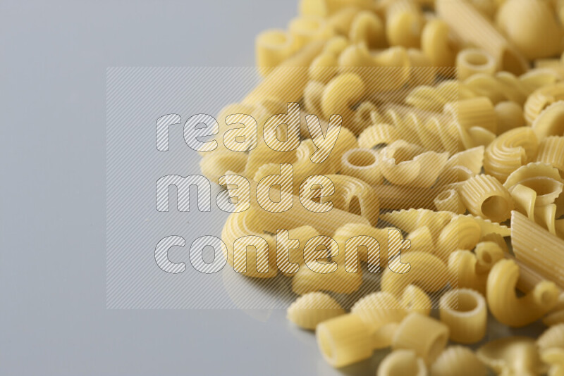 Different pasta types on light blue background