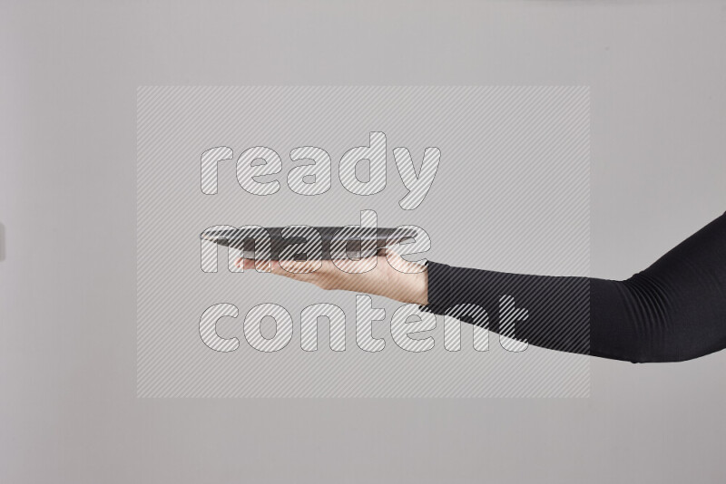 امرأة ترتدي عباءة سوداء تحمل أدوات فخارية مختلفة في أوضاع متعددة