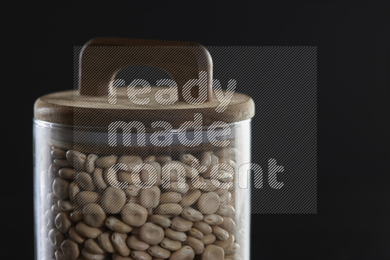 Lupin Beans in a glass jar on black background
