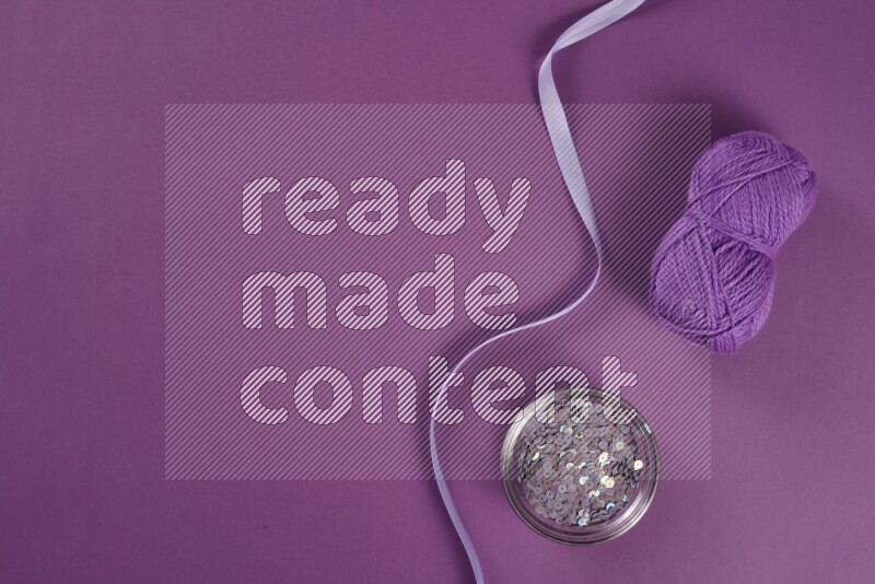 A purple collection of sewing and tailoring tools arranged on a purple background