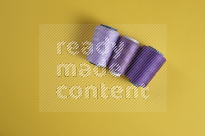 A purple collection of sewing and tailoring tools arranged on a yellow background