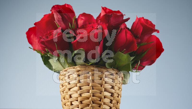 Vibrant red roses in a wicker basket on black marble background