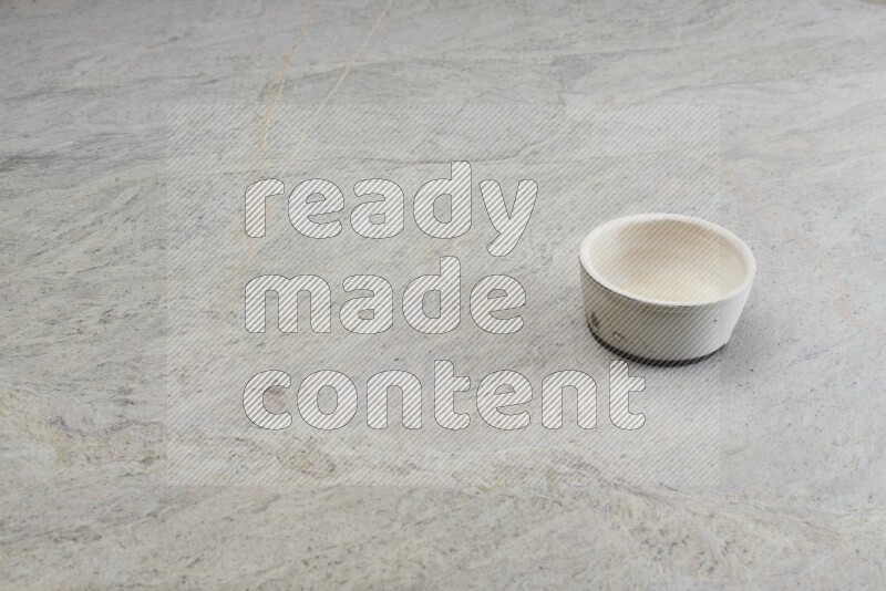 A white pottery bowl on grey marble background