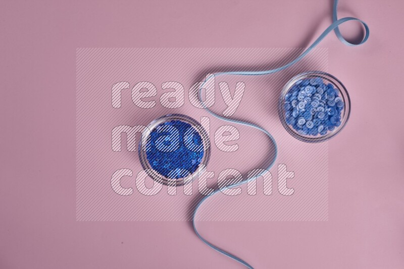 مجموعة من أدوات الخياطة والتفصيل زرقاء اللون على خلفية زهرية