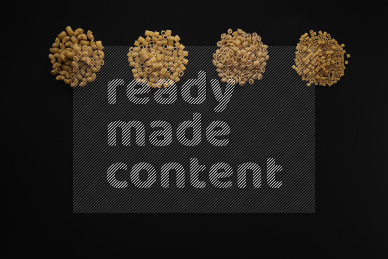 Different pasta types in 4 bunches on black background