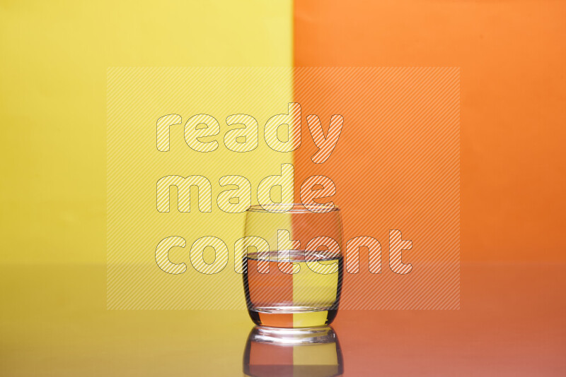 The image features a clear glassware filled with water, set against yellow and orange background