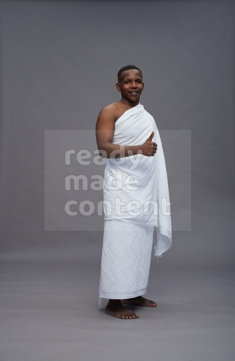 A man wearing Ehram Standing Interacting with the camera on gray background