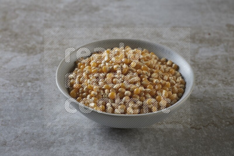 corn kernel in a gray ceramic bowl on a grey textured countertop