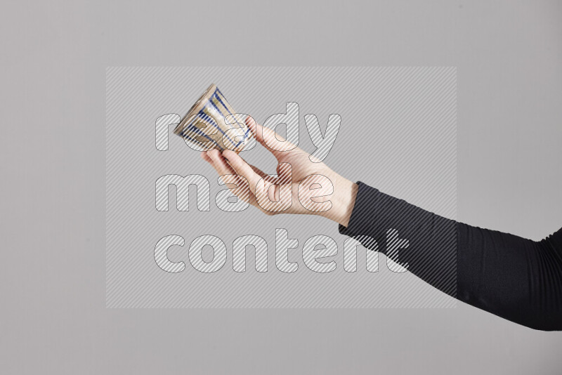 امرأة ترتدي عباءة سوداء تحمل أدوات فخارية مختلفة في أوضاع متعددة