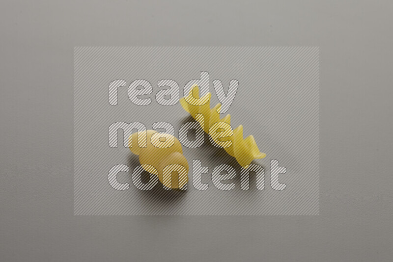 Snails pasta with other types of pasta on grey background