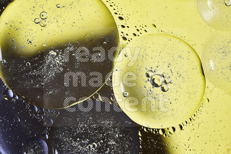 Close-ups of abstract oil bubbles on water surface in shades of black and yellow