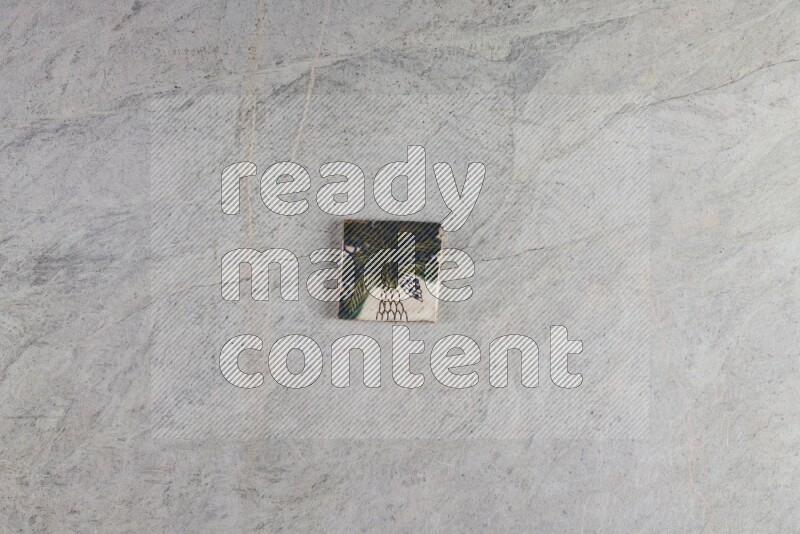 A decorative pottery coaster on grey marble background