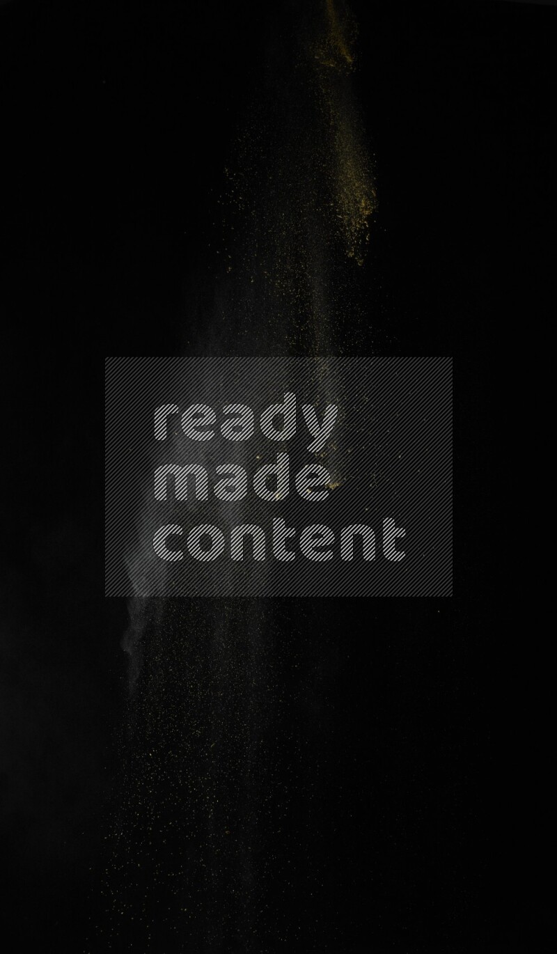 A side view of yellow powder explosion on black background
