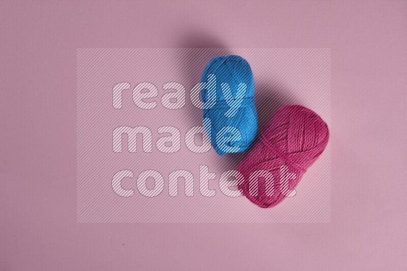 A blue collection of sewing and tailoring tools arranged on a pink background