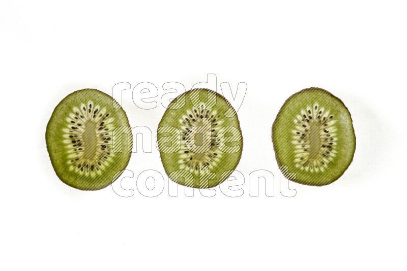 Kiwi slices on illuminated white background