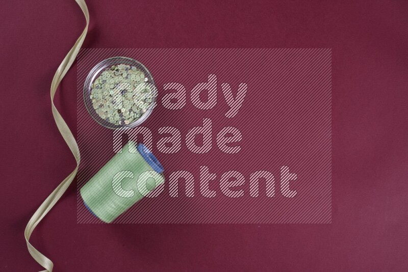 A green and red collection of sewing and tailoring tools arranged on a red background