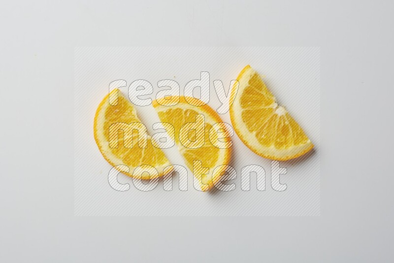 Three halves of an orange slices on white background