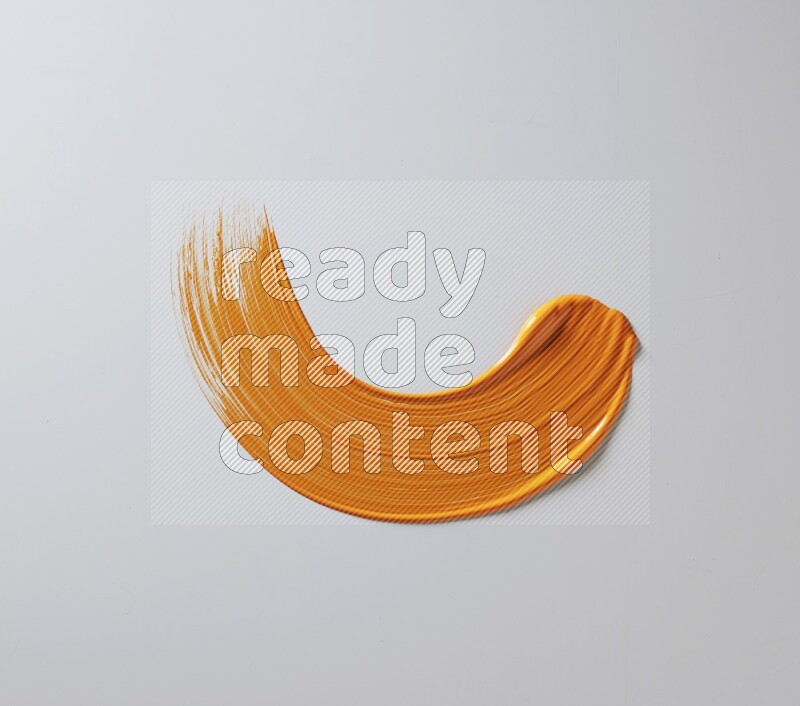 An orange half circular painting brush stroke on white background