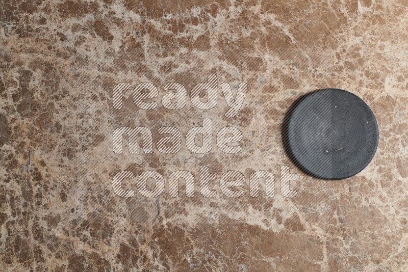 A pottery coaster on beige marble background