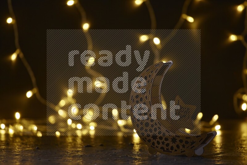 A traditional ramadan lantern surrounded by glowing fairy lights in a dark setup