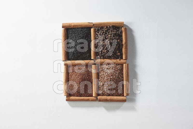 4 squares of cinnamon sticks full of black seeds, cloves, flaxseeds and garden cress on white flooring