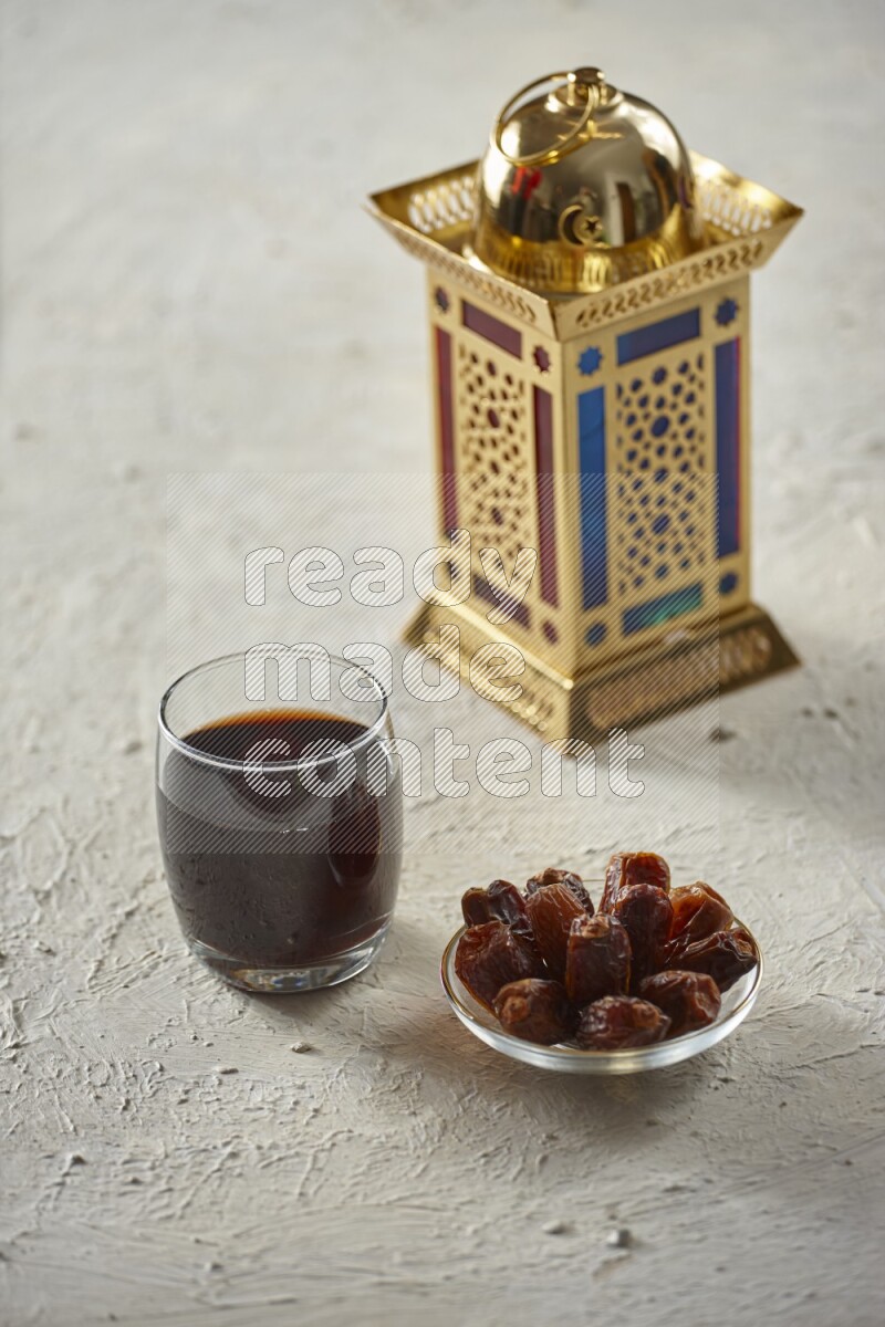 A golden lantern with different drinks, dates, nuts, prayer beads and quran on textured white background