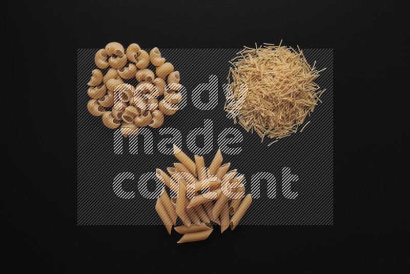 Different pasta types in bunches on black background