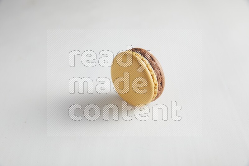 45º Shot of Yellow and Brown Chai Latte macaron on white background