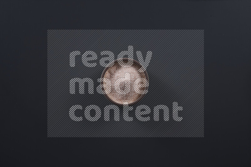 Pottery bowl full of fine himalayan salt and coarse himalayan salt on black background