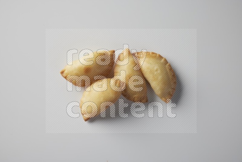 Four fried sambosa from a top angle on a white background